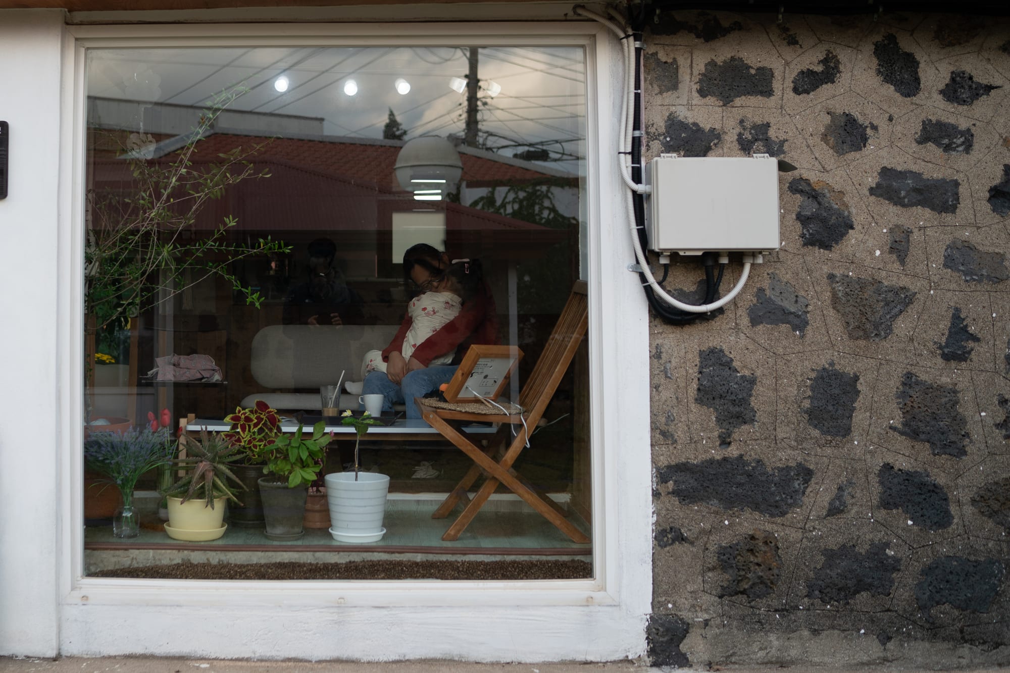 People sit together inside a room seen through a reflective window.