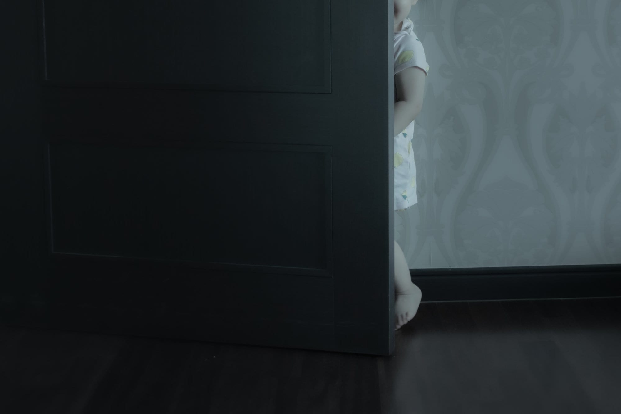 Part of a child visible behind a door.